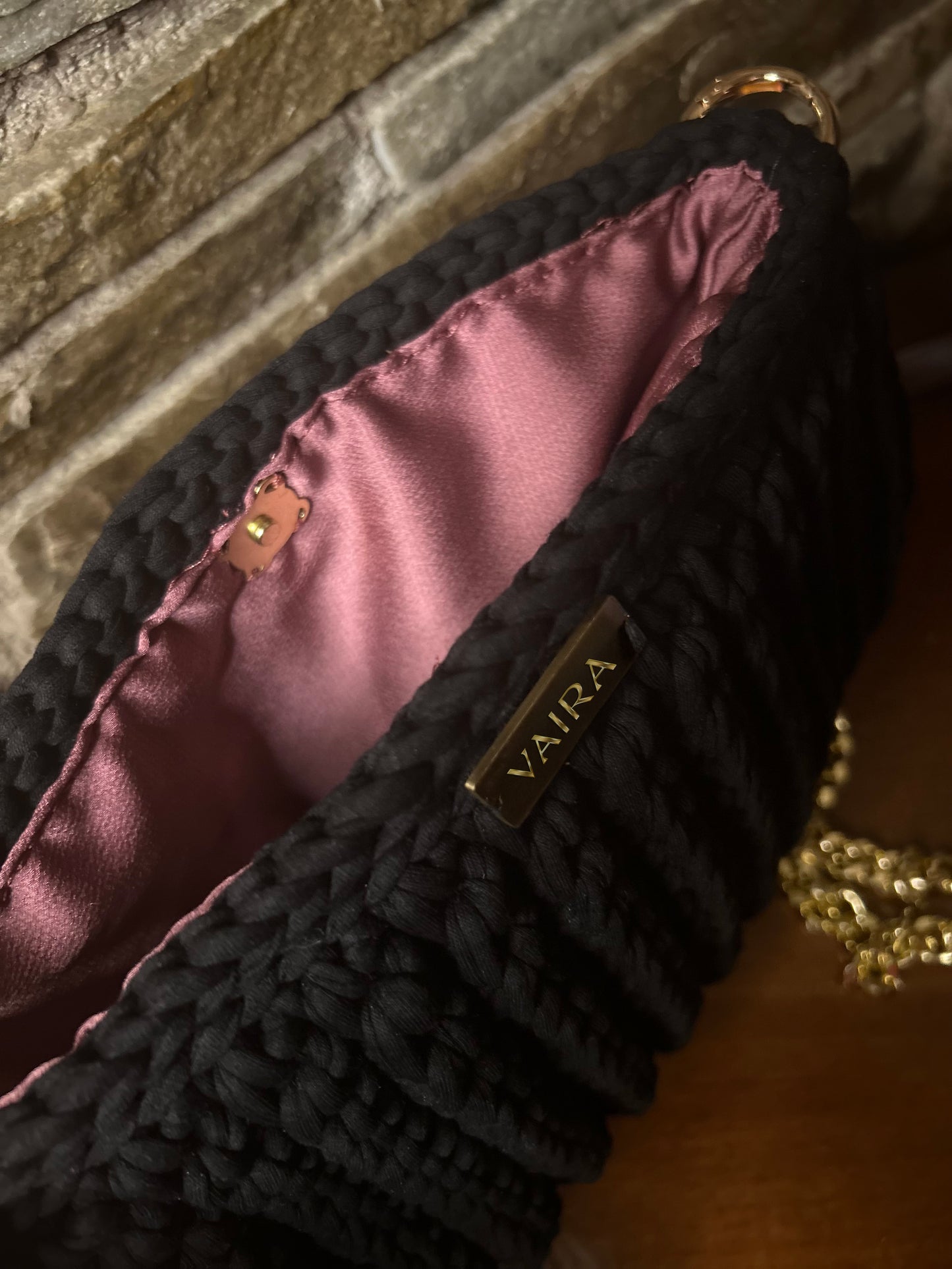 Handmade black crochet shoulder bag, featuring a gold chain strap, side keychain, zipper closure, and inner lining