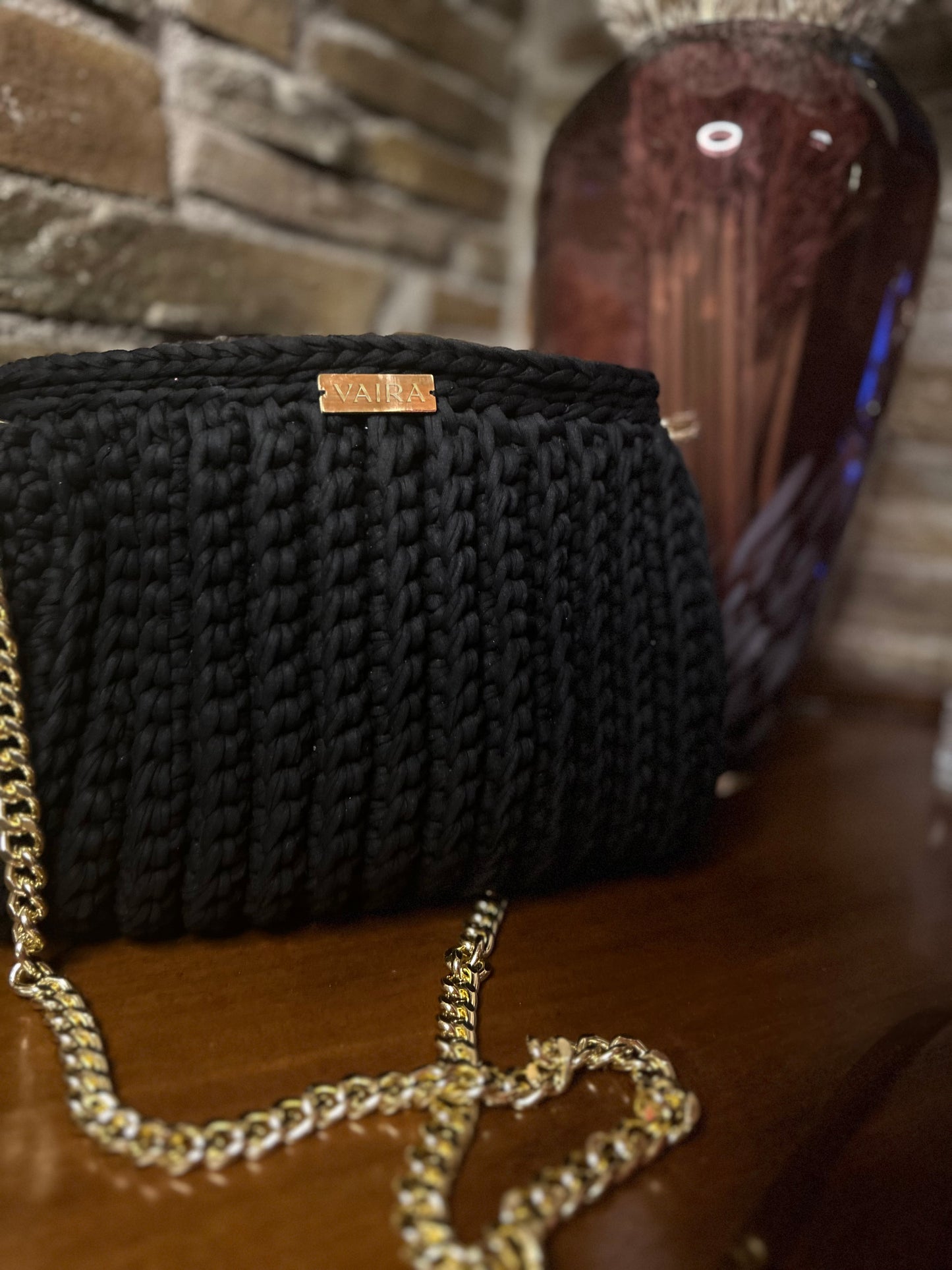 Handmade black crochet shoulder bag, featuring a gold chain strap, side keychain, zipper closure, and inner lining