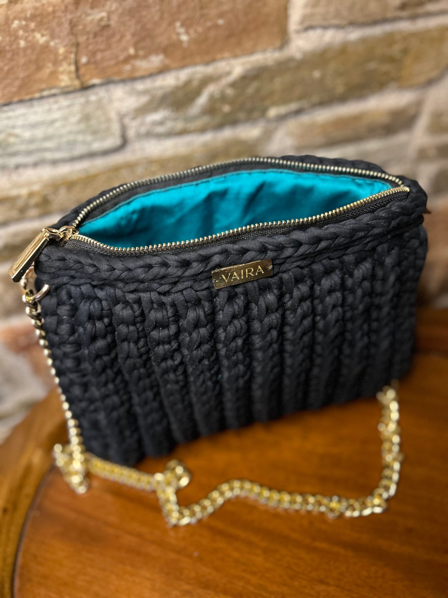 Handmade blue and black crochet shoulder bag, featuring a gold chain strap, side keychain, zipper closure, and inner lining