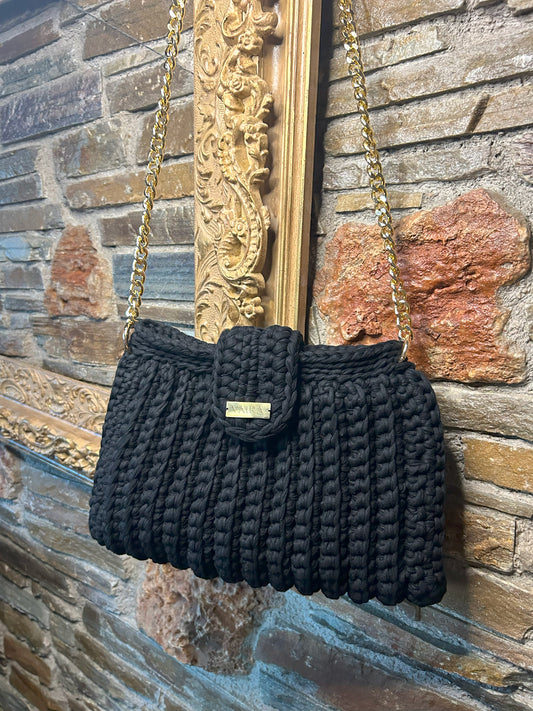 Handmade black crochet shoulder bag, featuring a gold chain strap, side keychain, zipper closure, and inner lining