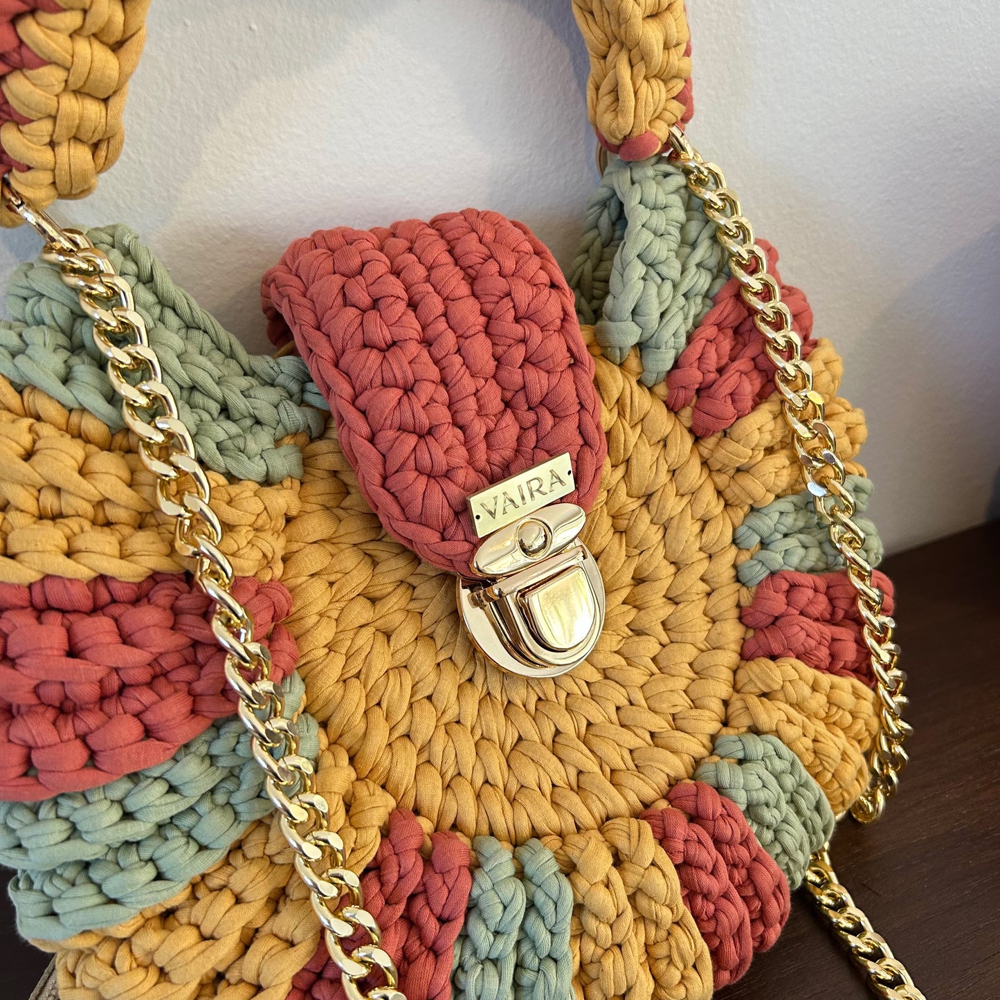 Handmade round multicolor crochet shoulder bag, featuring a metal and thread strap.