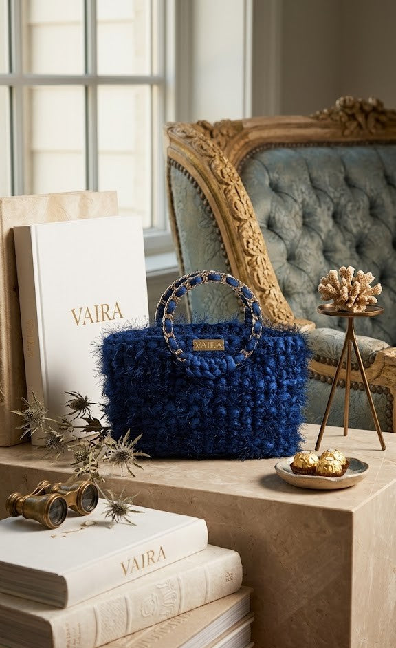 Μπλε statement bag Vibra με χειροποίητη πλέξη και χρυσή μεταλλική ταυτότητα VAIRA. Η χαρακτηριστική shaggy υφή και η λεπτομέρεια στη λαβή την καθιστούν ένα μοναδικό αξεσουάρ υψηλής ραπτικής.