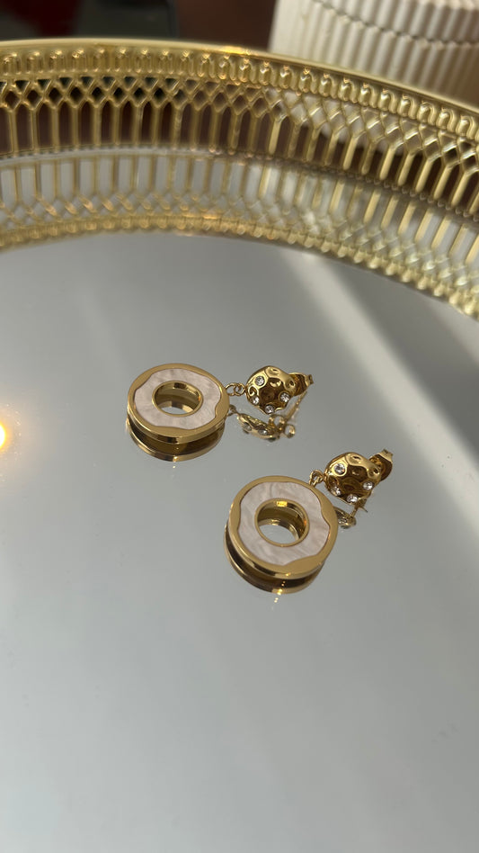 Γυναίκα που φοράει τα Celestial Orb σκουλαρίκια με φίλντισι και ανάγλυφο χρυσό στοιχείο.