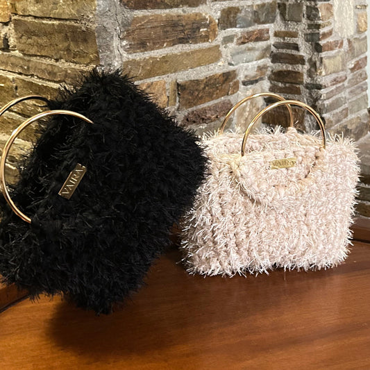 Γυναίκα που κρατάει τη χειροποίητη τσάντα VIVRA με χρυσή αλυσίδα