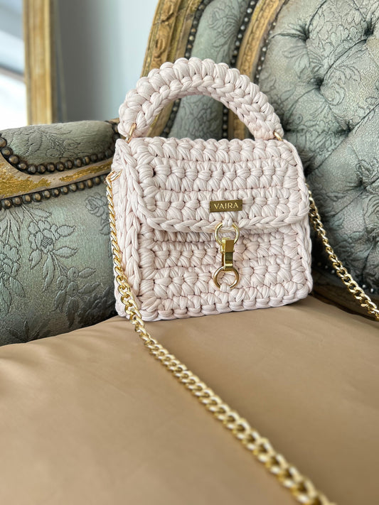 Entirely handcrafted with a unique stitch and golden chain, this petite yet charming shoulder bag brings everyday elegance to life. Perfectly sized for your essentials, it features a standout closure and luxurious texture — a true style statement born from the art of handmade creation.