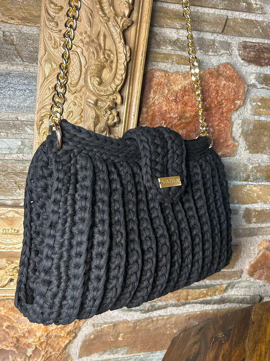 Handmade black crochet shoulder bag, featuring a gold chain strap, side keychain, zipper closure, and inner lining