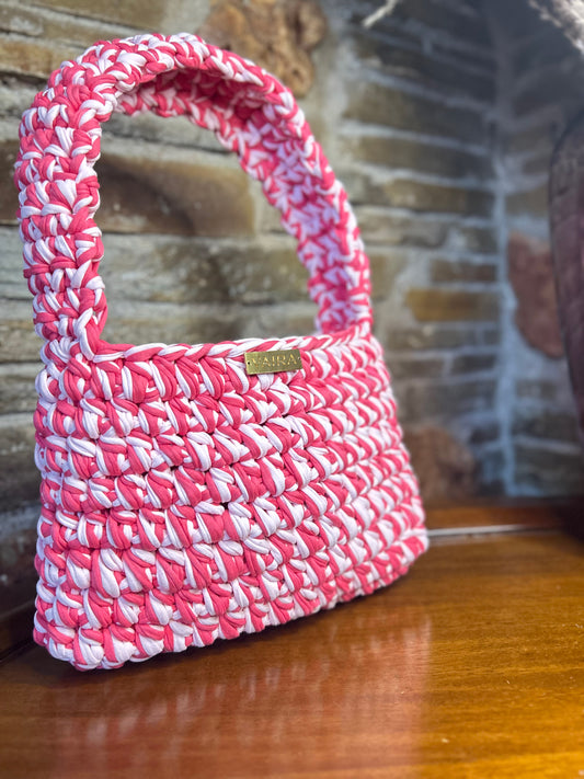 Handwoven shoulder bag with gold chain and delicate fringes, featuring a boho-chic and playful feminine vibe.