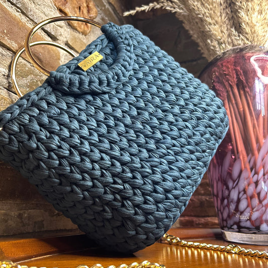 Handcrafted cotton handbag in a soft, elegant shade. Features distinctive textured weaving and a refined lining for a luxurious finish. Includes versatile handles and a detachable gold-tone chain for shoulder, crossbody, or handheld wear. Stylish and practical for day-to-night looks. Made in Greece with waterproofing treatment for stain resistance.